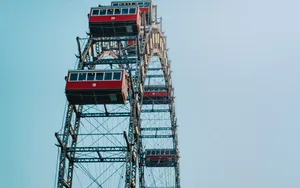 Das Wiener Riesenrad mit seinen roten Kabinen vor dem blauen Himmel