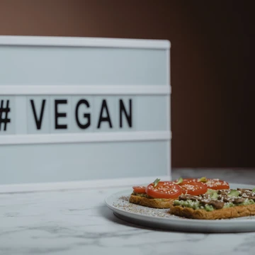 Teller mit Broten, dahinter Aufschrift vegan