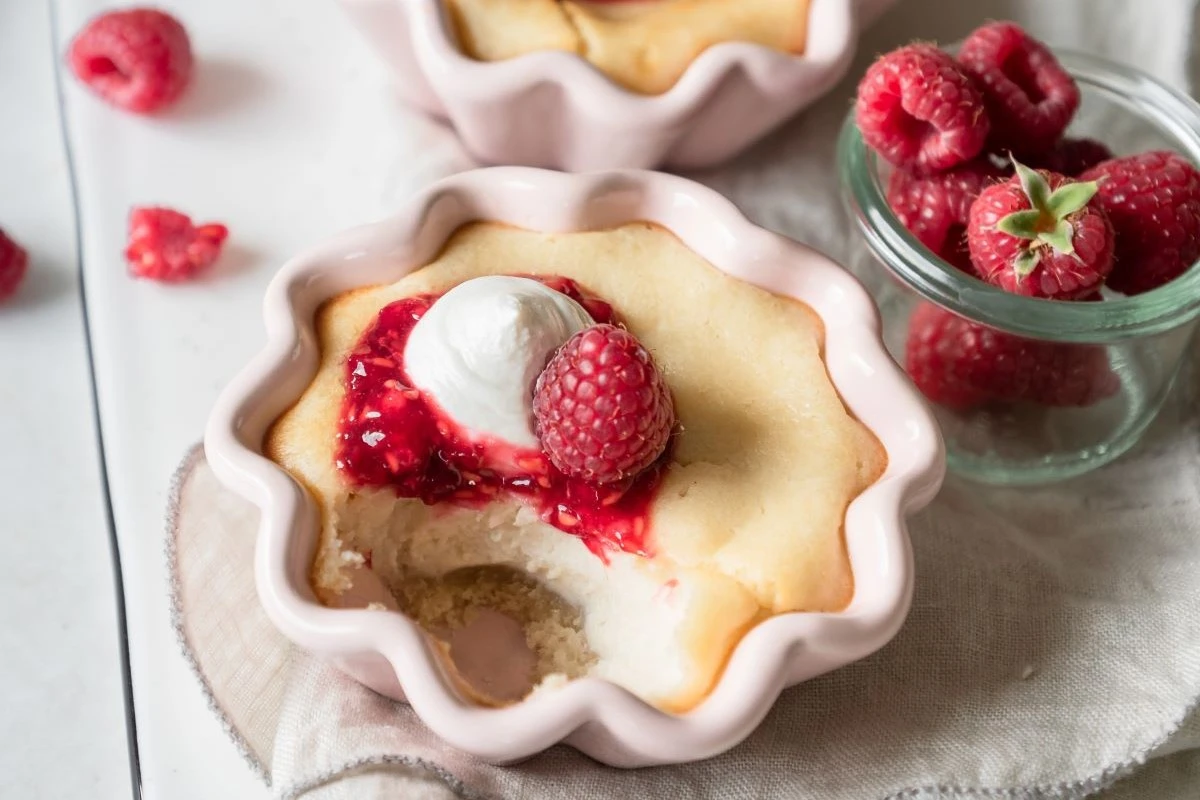 Kleine Käsekuchen in sternförmigen Schüsselchen, mit Himbeeren angerichtet