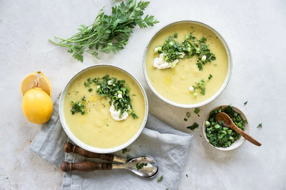 Zwei Suppenteller mit Kartoffel-Lauch-Suppe, garniert mit Kräutern