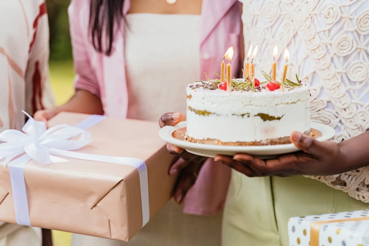 Geschenke und eine Geburtstagstorte mit Kerzen