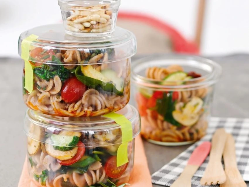 Mediterraner Nudelsalat in mehreren kleinen durchsichtigen Behältnissen.